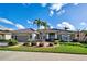 Charming single-story home with a well-manicured lawn, mature landscaping, and a tile roof at 594 Sawgrass Bridge Rd, Venice, FL 34292