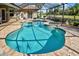 Inviting screened-in pool and spa area with paver deck, perfect for entertaining or relaxation at 594 Sawgrass Bridge Rd, Venice, FL 34292