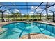 Private screened-in pool and spa overlook lush landscaping, offering a serene outdoor oasis at 594 Sawgrass Bridge Rd, Venice, FL 34292