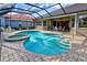 Beautiful screened-in pool and spa with lush landscaping, creating a private backyard retreat at 594 Sawgrass Bridge Rd, Venice, FL 34292