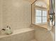 Walk-in shower boasts neutral tiling, a built-in bench, and a window for natural light at 594 Sawgrass Bridge Rd, Venice, FL 34292
