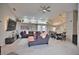 Open living room features a sectional sofa, large TV, and views into the kitchen and dining area at 5280 E Sunnydale Cir, Sarasota, FL 34233