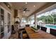 Covered outdoor kitchen with built-in grill, granite counters, and dining area at 5280 E Sunnydale Cir, Sarasota, FL 34233