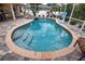 Freeform swimming pool with a spa and brick patio at 5280 E Sunnydale Cir, Sarasota, FL 34233