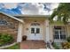 Front entry with double doors, stonework, and landscaping at 5280 E Sunnydale Cir, Sarasota, FL 34233