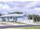 Newly constructed light blue single-Gathering home with a white garage door and landscaped yard at 17501 Belle Eden Way, Nokomis, FL 34275