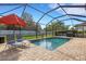 Screened-in pool area with lounge chairs and an umbrella at 19304 Bluff Dr, Venice, FL 34292
