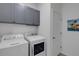 Convenient laundry room with upper cabinets and a modern washer/dryer at 19304 Bluff Dr, Venice, FL 34292