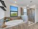 Relax in this bathroom, featuring a large soaking tub and walk-in shower at 19304 Bluff Dr, Venice, FL 34292