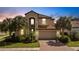 Two-story house with a red tile roof, palm trees, and a brick driveway at 19304 Bluff Dr, Venice, FL 34292