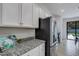 Modern kitchen with white cabinets, granite countertops, and stainless steel appliances at 19304 Bluff Dr, Venice, FL 34292
