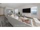 Virtually staged living room with a white sofa and large TV at 1622 Monarch Dr # 1622, Venice, FL 34293