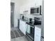 Modern kitchen with white cabinets, granite countertops, and stainless steel appliances at 17505 Belle Eden Way, Nokomis, FL 34275