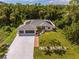 Single-Gathering home with a large backyard, driveway, and surrounding trees at 16093 Hillsborough Blvd, Port Charlotte, FL 33954