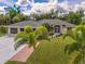 Single-story house with a three-car garage and a well-maintained lawn at 16093 Hillsborough Blvd, Port Charlotte, FL 33954