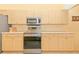 Modern kitchen with stainless steel appliances and light wood cabinets at 16093 Hillsborough Blvd, Port Charlotte, FL 33954