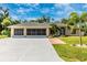 Single-Gathering home with three-car garage, landscaping, and a large driveway at 16093 Hillsborough Blvd, Port Charlotte, FL 33954