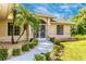 Front entrance with a curved walkway, landscaping, and a screened door at 16093 Hillsborough Blvd, Port Charlotte, FL 33954
