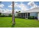 View of the home's exterior with a screened patio and green lawn at 451 Wexford Cir, Venice, FL 34293