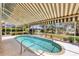 Relaxing pool area with a screened enclosure and striped awning at 1136 Highland Greens Dr, Venice, FL 34285