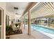 Covered patio with pool view, seating area and lush landscaping at 1136 Highland Greens Dr, Venice, FL 34285