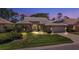 Well-lit home at dusk showcasing architectural details and landscaping at 1136 Highland Greens Dr, Venice, FL 34285