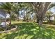 Landscaped backyard with a large tree and lush green grass at 1136 Highland Greens Dr, Venice, FL 34285