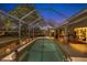 Enjoy the tranquil screened pool area at night at 1136 Highland Greens Dr, Venice, FL 34285