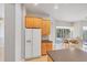 Kitchen with wood cabinets, white refrigerator, and view to backyard at 1311 Tuscany Blvd, Venice, FL 34292