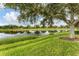 Peaceful pond view with lush landscaping and mature trees at 6057 Erice St, Venice, FL 34293