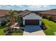 Single-story home with brown garage door and landscaped yard at 232 Carlino Dr, Nokomis, FL 34275