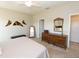 Main bedroom with king bed, dresser, and access to ensuite bathroom at 232 Carlino Dr, Nokomis, FL 34275