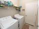 Laundry room with washer, dryer, and shelving at 232 Carlino Dr, Nokomis, FL 34275