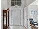 Bright entryway with white front door, wood flooring, and a grandfather clock at 23787 Waverly Cir, Venice, FL 34293