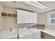 Bright laundry room with washer, dryer, and ample storage at 23787 Waverly Cir, Venice, FL 34293