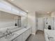Elegant bathroom with double vanity, large mirror, and a soaking tub at 23787 Waverly Cir, Venice, FL 34293