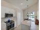 Kitchen with white cabinets, stainless steel appliances, and view of pool at 23787 Waverly Cir, Venice, FL 34293