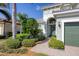 House entrance with green door, landscaping, and a brick pathway at 23787 Waverly Cir, Venice, FL 34293