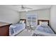 Twins bedroom with window, ceiling fan and blue bedding at 23787 Waverly Cir, Venice, FL 34293