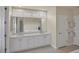 Bathroom with double vanity, large mirror, and a walk-in shower at 23787 Waverly Cir, Venice, FL 34293