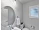 Small powder room with a round mirror and window with shutters at 23787 Waverly Cir, Venice, FL 34293