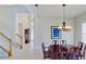 Elegant dining room with a dark wood table and chandelier, adjacent to the stairs at 23787 Waverly Cir, Venice, FL 34293