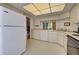 Bright kitchen features white cabinetry, modern appliances, and tile flooring at 201 Woodland Dr # 201, Osprey, FL 34229