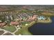 Aerial view of community clubhouse, pool, tennis courts, and parking at 10780 Tarflower Dr # 102, Venice, FL 34293