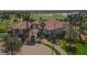 Community clubhouse with tile roof, palm trees, and a golf course view at 10780 Tarflower Dr # 102, Venice, FL 34293