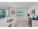 Modern kitchen with white cabinets, quartz countertops, and stainless steel appliances at 10780 Tarflower Dr # 102, Venice, FL 34293