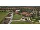 Aerial view of a community with houses, golf course, and clubhouse at 10780 Tarflower Dr # 102, Venice, FL 34293