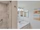 Clean bathroom with a shower, vanity with white cabinets, and gray tile at 10780 Tarflower Dr # 102, Venice, FL 34293