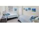 Two twin beds, gray dresser, and ocean-themed decor in a bright bedroom at 10780 Tarflower Dr # 102, Venice, FL 34293
