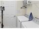 Bright laundry room with washer, dryer, and overhead shelving at 10780 Tarflower Dr # 102, Venice, FL 34293